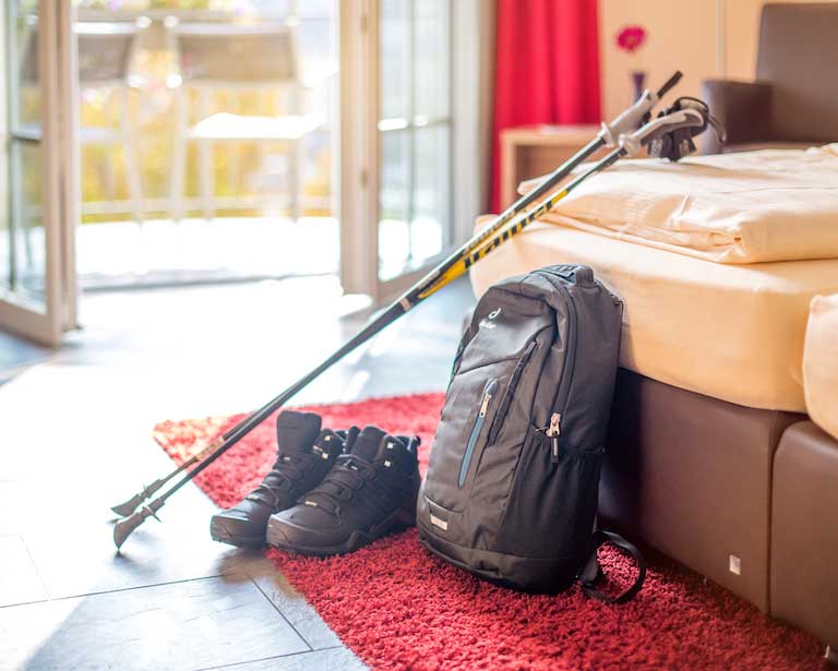 Rucksack mit Schuhen und Walking Stöcken steht bereit