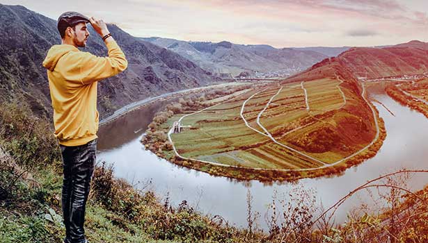 Mann steht auf einem Berg mit Ausblick auf die Mosel und genießt die Aussicht